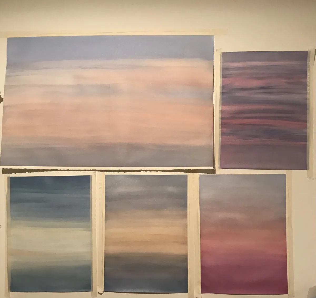 Atelieransicht: mehrere Wolkengemälde nebeneinander an einer Atelierwand